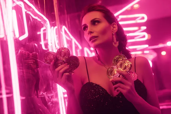 A glamorous woman holding casino chips in a neon-lit environment, representing the premium online casino atmosphere of DBJL.